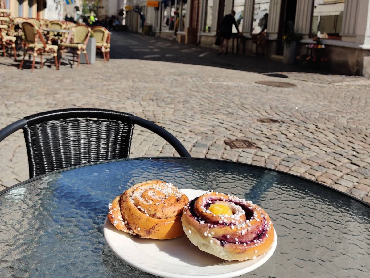En kanelbulle med pärlsocker på ett bord på uteserveringen