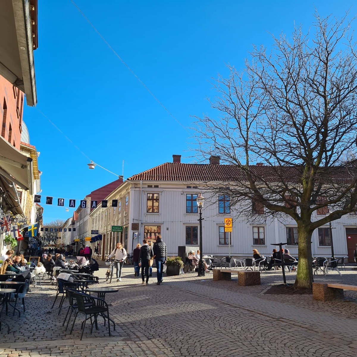 Haga Nygata med trähus, kullersten och kaféets bord i förgrunden