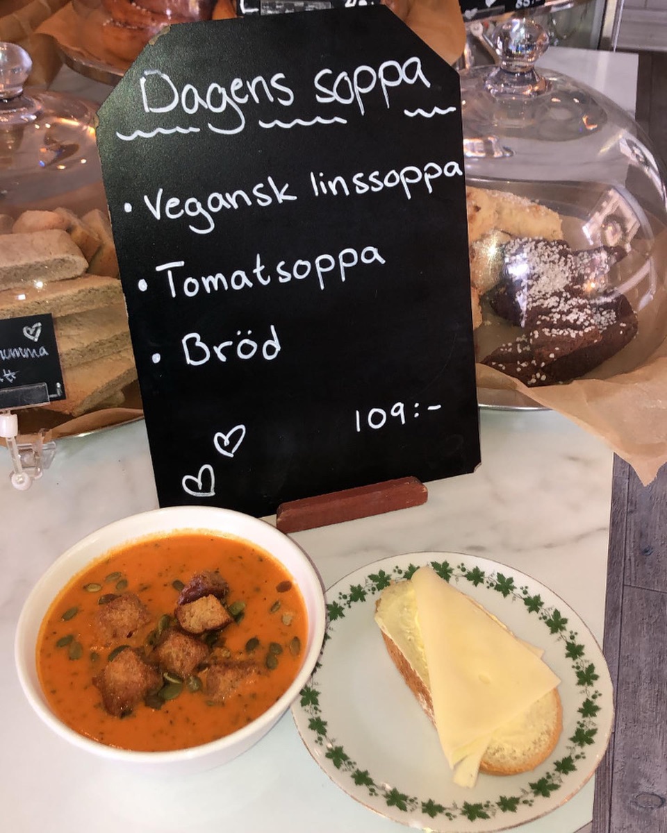 Dagens soppa på tavlan: vegansk linssoppa och tomatsoppa, med en tallrik soppa och bröd